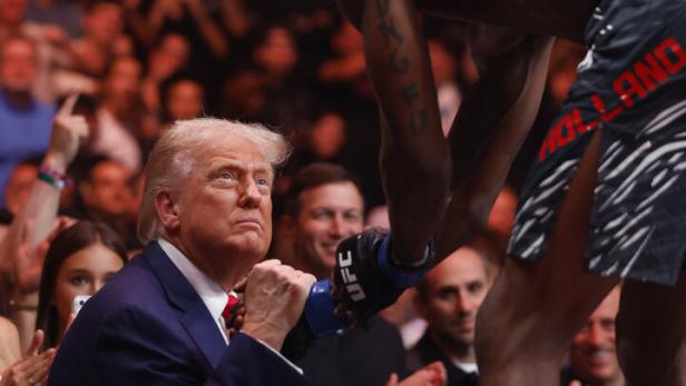 Trump schüttelt einem MMA-Kämpfer die Hand.