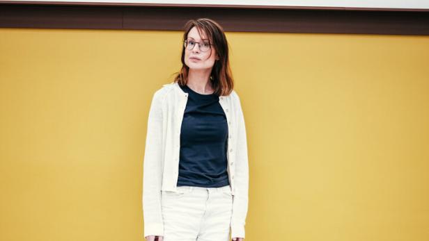 Fatima Hellberg, neue Direktorin am Mumok, vor gelb-weißer Wand, in schwarz-weißer Kleidung