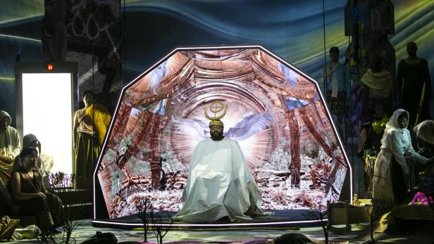 Bunte, von KI-Bildern bespielte Bühne der Oper "Parsifal"