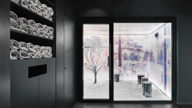 Ein Snow Room mit schneebedecktem Baum und Holzhockern
