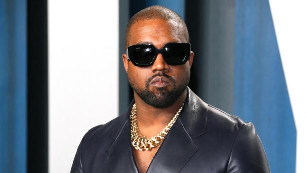 Der US-Rapper Kanye West mit Sonnenbrille und Goldkette 2020 auf einer Fashion-Show 
