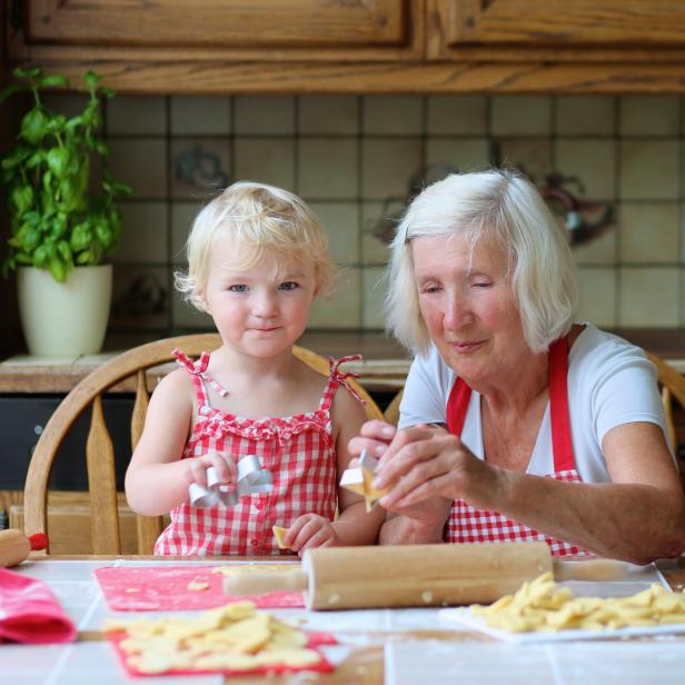 Ein Kind und seine Oma backen Kekse.