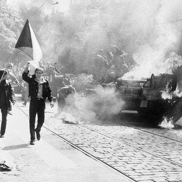 Einwohner von Prag mit tschechoslowakischer Flagge vor einem sowjetischen Panzer