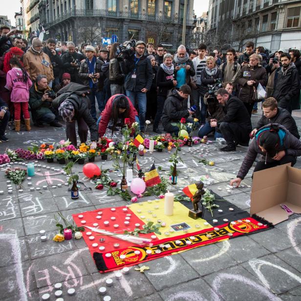 Menschen zünden Kerzen an und legen Blumen nieder am Place de la Bourse (Beursplein) in Brüssel im Gedenken an die Opfer der gestrigen Anschläge