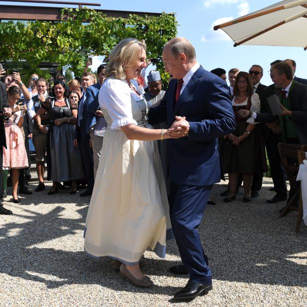 Karin Kneissl und Wladimir Putin tanzen, während die Hochzeitsgäste zusehen.