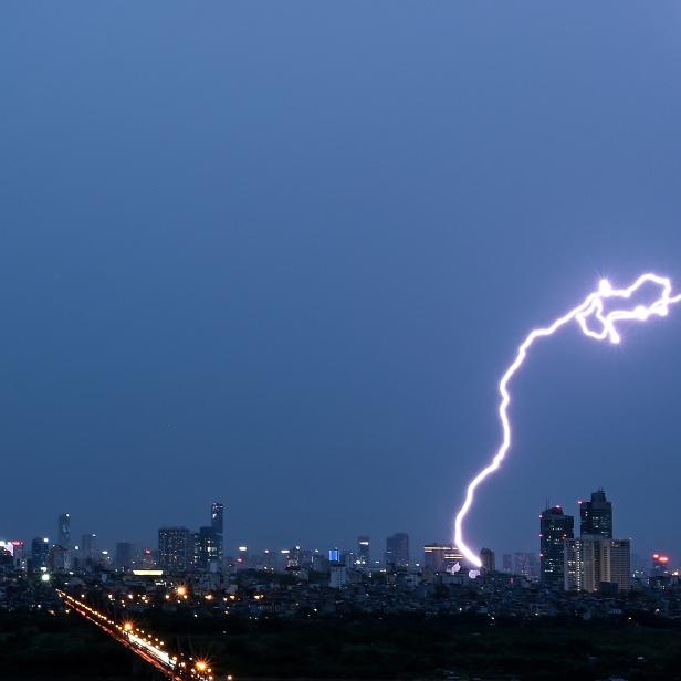 Ein Blitz schlägt über der Skyline von Hanoi ein.