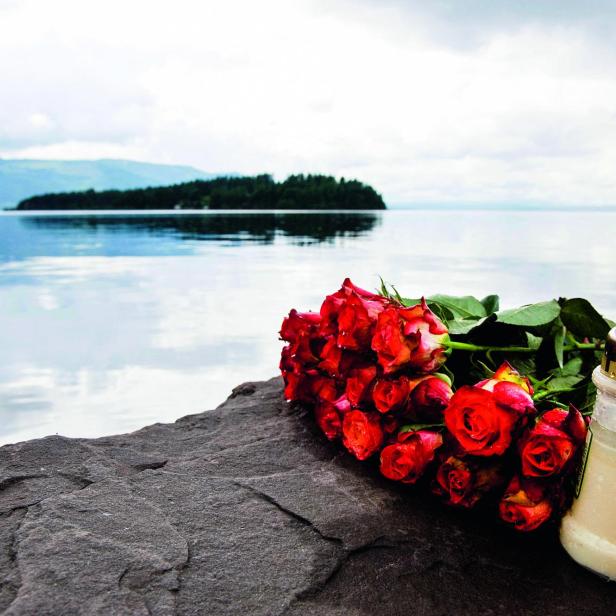 Rosen und eine Kerze als Gedenken auf der Insel Utøya