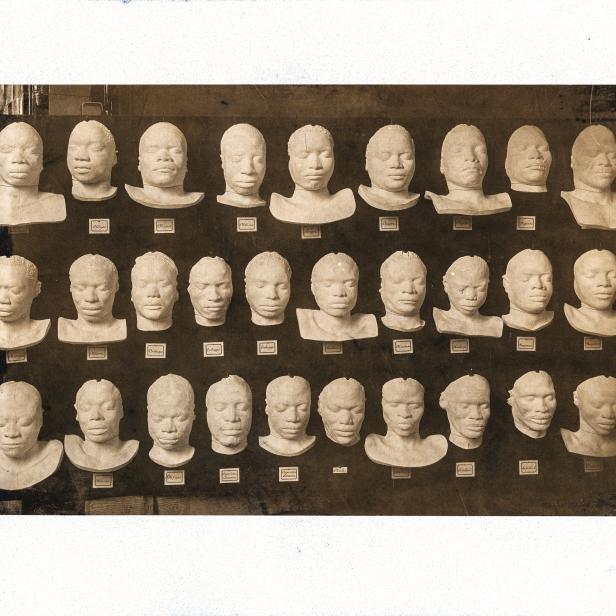 Ansicht einer Schautafel mit 29 Gesichtsmasken verschiedener ostafrikanischer Ethnien, vom Lebenden abgegossen an der Gipsformerei der Königlichen Museen zu Berlin.