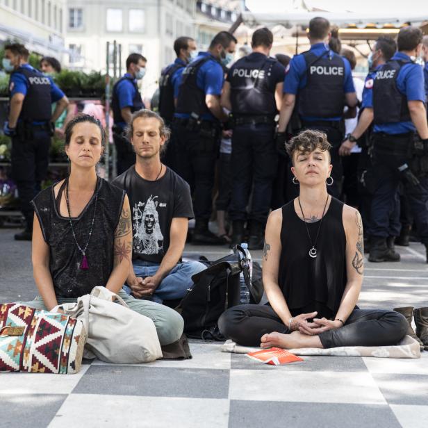 Menschen im Schneidersitz bei einer Corona-Demo