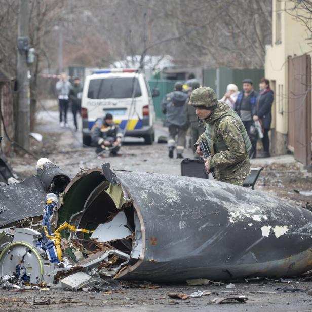 Ein Soldat der ukrainischen Armee inspiziert Fragmente eines abgeschossenen Flugzeugs in Kiew, Ukraine, Freitag, 25. Februar 2022.