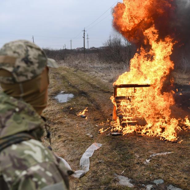 Ein ukrainischer Soldat blickt auf Flammen, nachdem er während eines Selbstverteidigungskurses für Zivilisten am 4. März 2022 am Stadtrand von Lemberg (Westukraine) einen Molotow-Cocktail geworfen hat.