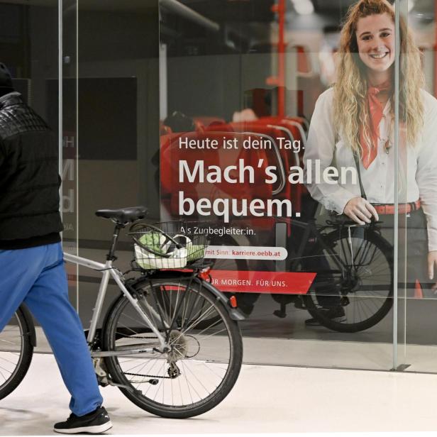 Bild vom Bahnhof Salzburg: Eine Person schiebt ein Fahrrad am Bahnhof. 