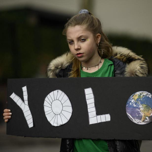 Ein Mädchen hält während eines Jugend-Klimastreiks vor dem New Yorker Hauptquartier der Vereinten Nationen ein Schild mit der Aufschrift „YOLO“ (Man lebt nur einmal).