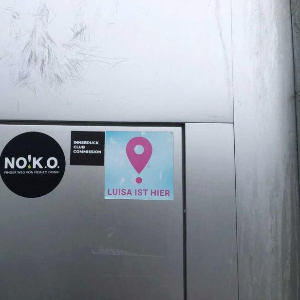 Man sieht die Tür eines Clubs in Tirol, auf der die Sticker der "Luisa-ist-hier"- Kampagne und der Sticker der Innsbruck Club Commission kleben