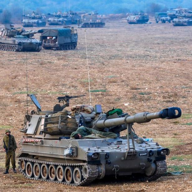 An Israeli soldier rests on an artillery cannon as his comrade stands guard at an undisclosed location in northern Israel bordering Lebanon on October 8, 2023. Fighting between Israeli forces and the Palestinian militant group Hamas raged on October 8, with hundreds killed on both sides after a surprise attack on Israel prompted Prime Minister Benjamin Netanyahu to warn they were &quot;embarking on a long and difficult war&quot;. (Photo by JALAA MAREY / AFP)