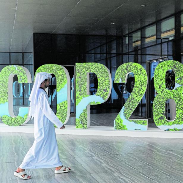 FILE PHOTO: A person walks past a "#COP28" sign during The Changemaker Majlis, a one-day CEO-level thought leadership workshop focused on climate action, in Abu Dhabi