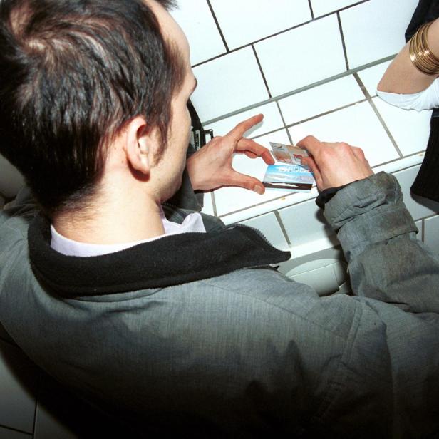 Zwei Personen konsumieren Drogen auf der Toilette.