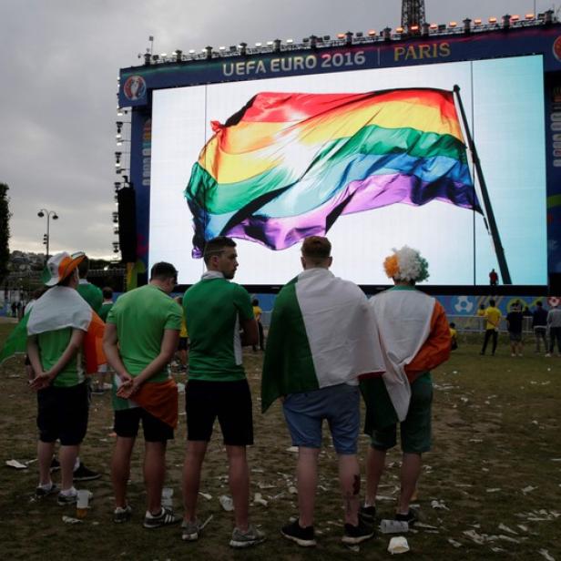 This file photo taken on June 13, 2016 shows supporters standing in front of a giant screen displaying a rainbow flag to pay tribute to the victims of the shooting of Orlando, in a fan zone in Paris during the Euro 2016 football tournament on June 13, 2016. .More than three-quarters of football fans across the globe would have no problem if a player in their national team came out as gay or bisexual, a poll showed on December 13, 2017. Conducted by fan-opinion platform Forza Football and campaign group Stonewall, the survey asked more than 50,000 supporters in 38 countries about their attitudes towards inclusion and homophobia / AFP PHOTO / Thomas SAMSON