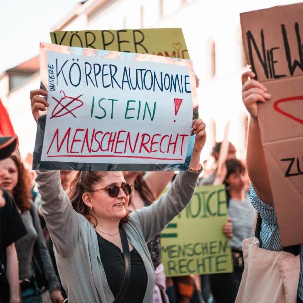 Ein Pro-Choice-Protest; Frau hält Schild hoch, auf dem steht: "Körperautonomie ist ein Menschenrecht!"