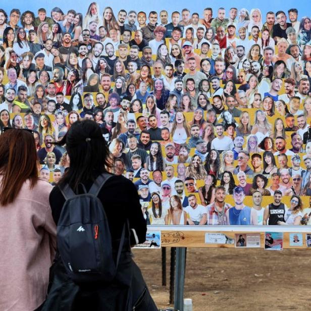 sraelis visit a memorial bearing portraits of people taken hostage or killed in the Hamas attack on the Supernova music festival on October 7 at the site of the festival near Kibbutz Reim in southern Israel on April 10, 2024. (Photo by JACK GUEZ / AFP)