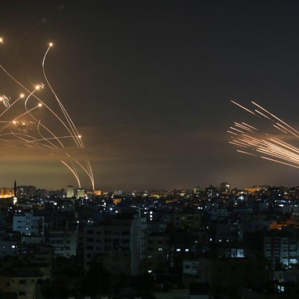 TOPSHOT - Rockets are seen in the night sky fired towards Israel from Beit Lahia in the northern Gaza Strip on May 14, 2021. - Israel bombarded Gaza with artillery and air strikes on Friday, May 14, in response to a new barrage of rocket fire from the Hamas-run enclave, but stopped short of a ground offensive in the conflict that has now claimed more than 100 Palestinian lives As the violence intensified, Israel said it was carrying out an attack "in the Gaza Strip" although it later clarified there were no boots on the ground. (Photo by ANAS BABA / AFP)