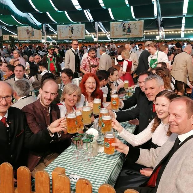 Menschen sitzen an einem Tisch und trinken Bier