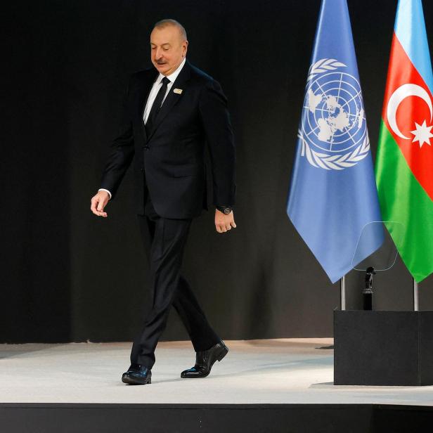 Aserbaidschans Präsident Ilham Aliyev vor Flaggen der UN und Aserbaidschan bei der cop29