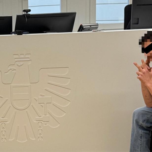 Junger Bursche sitzt auf Angklagebank vor Gericht und hebt drei Finger hoch, den Serbengruß.