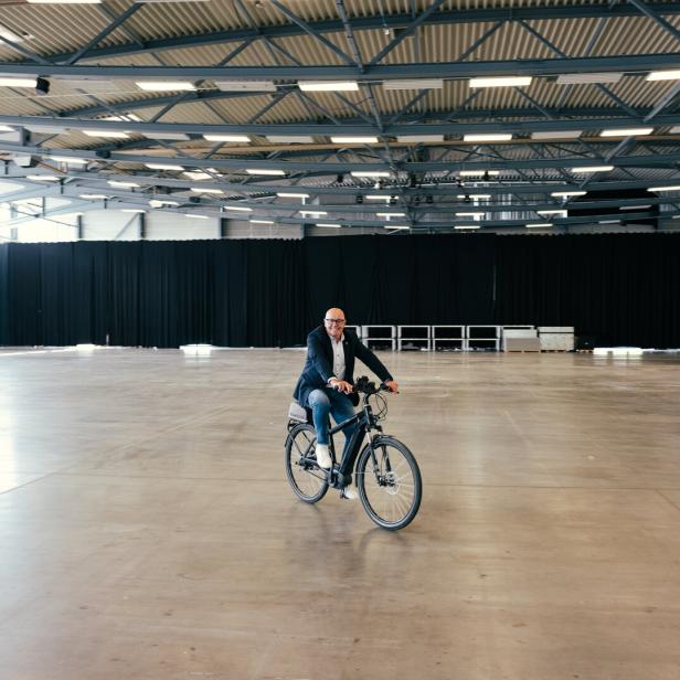 Georg Rosner, ÖVP-Bürgermeister von Oberwart, fährt mit seinem Rad durch die örtliche Messehalle.