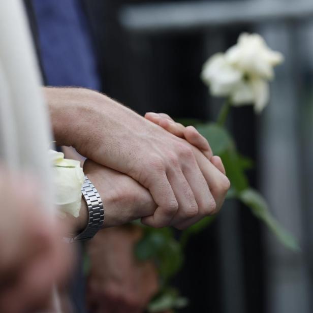 Hände und eine weiße Rose