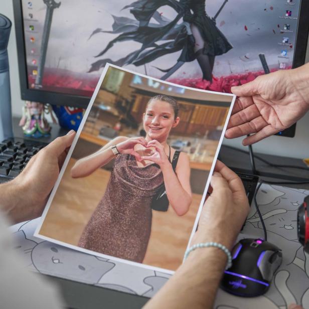 Anna Bella Bernharts Eltern halten ein Foto von ihr in den Händen