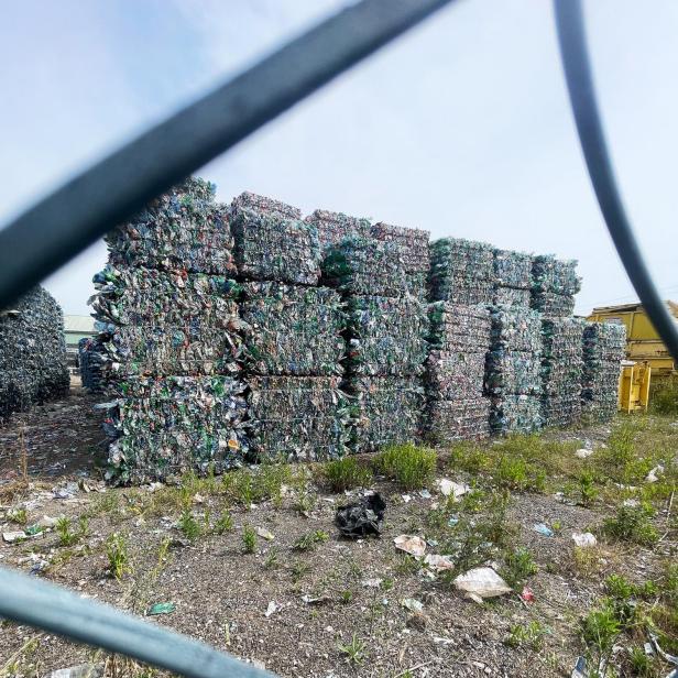 Zusammengepresstes Einwegpfand stapelt sich am Areal der Sortieranlage