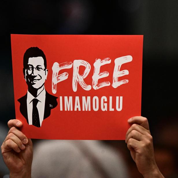 Demonstrant hält Schild hoch und fordert Freiheit für İmamoğlu 