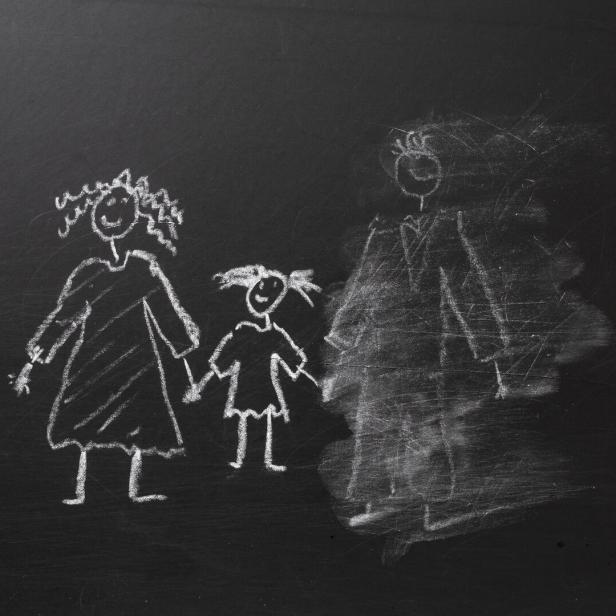 Chalk drawing of a child and parents on a blackboard, divorce concept