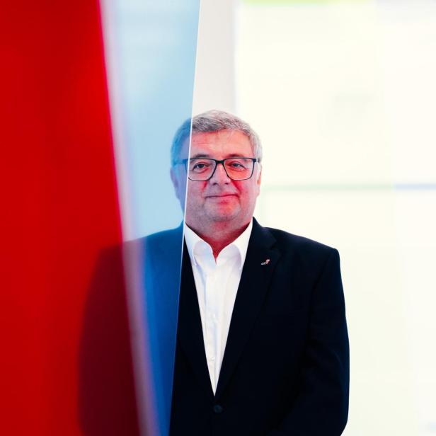 Jörg Leichtfried steht hinter einer roten Plexiglasscheibe 