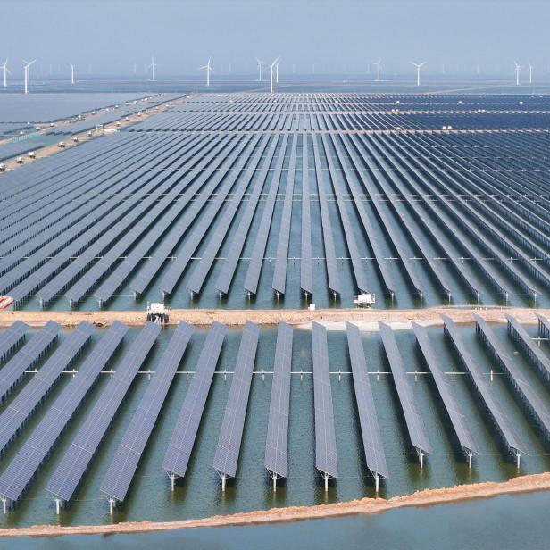 Auf dem Bild befinden sich Photovoltaikanlagen und Windräder in China