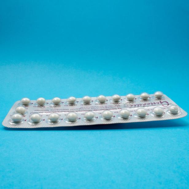 Eine volle Pillenpackung vor blauem Hintergrund 