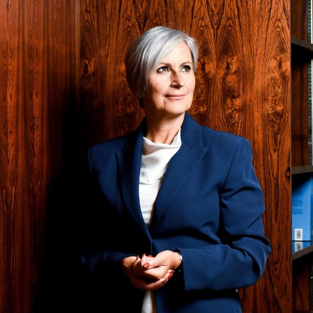 Anna Sporrer steht vor einer Holzwand in ihrem Büro 