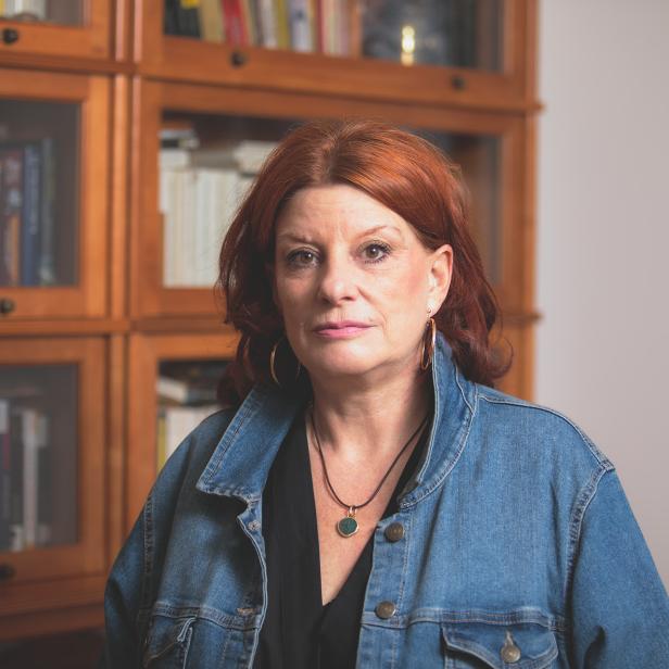 Buchautorin Dr.in Birgit Kofler Bettschart steht vor Bücherschrank