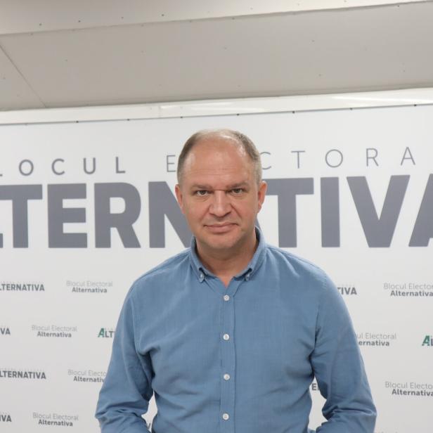 Ein Mann in Hemad steht vor dem Schriftzug "Blocul Electoral Alternativa"