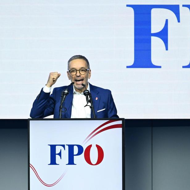 FPÖ-Chef Herbert Kickl steht hinter einem Pult und hält mit erhobener Faust eine Rede.