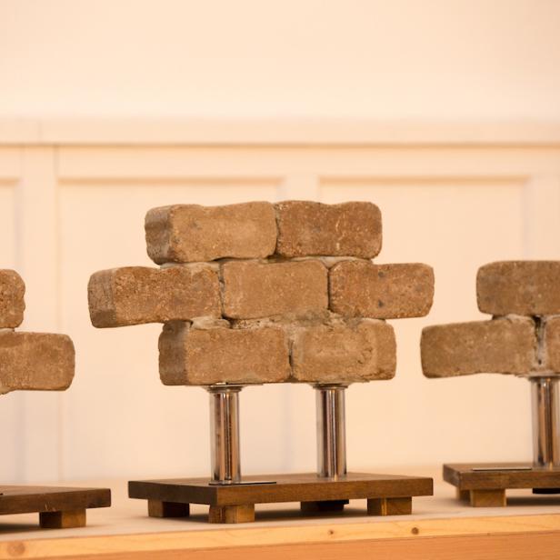 Die Trophäen des Negativpreises „Die Mauer des Schweigens“ aus Ziegelsteinen auf Sockeln, vergeben vom Forum Informationsfreiheit, stehen nebeneinander auf einem Tisch.