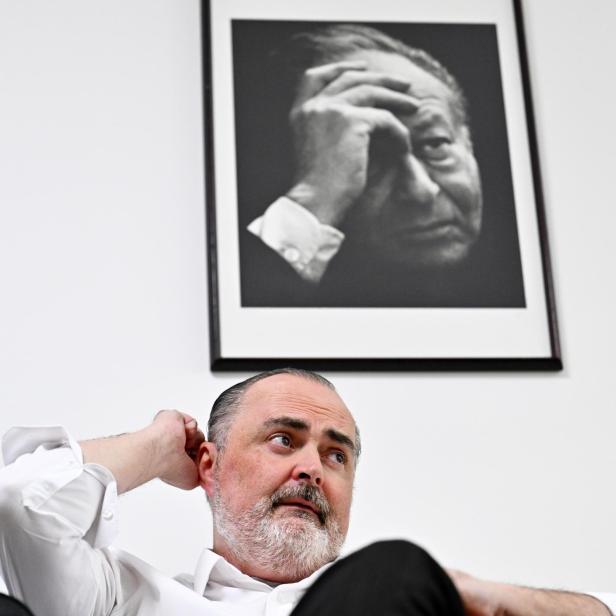 Hans Peter Doskozil sitzt nachdenklich unter einem großen Schwarzweiß-Porträt von Bruno Kreisky.