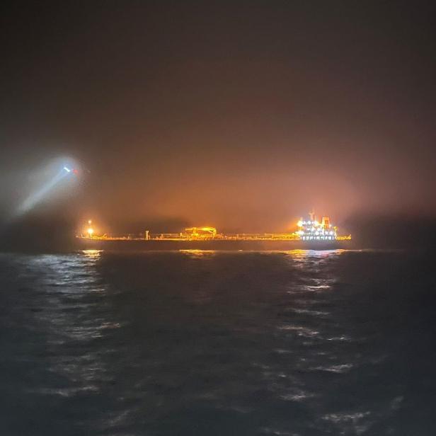 Ein Hubschrauber kreist in der Nacht über dem Öltanker Eagle S