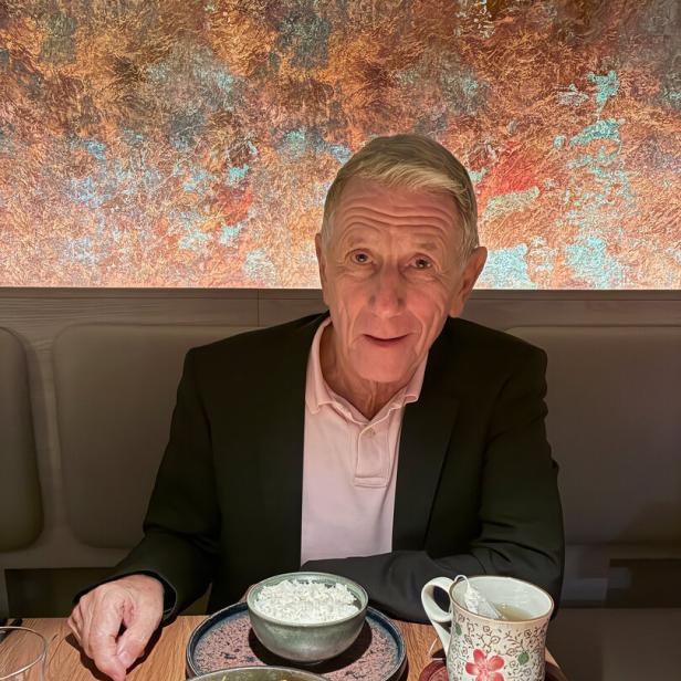 Peter Hochegger, Ex-PR-Manager, trägt Poloshirt und Anzug und sitzt in einem Restaurant vor einer Schüssel Reis und Thai-Curry