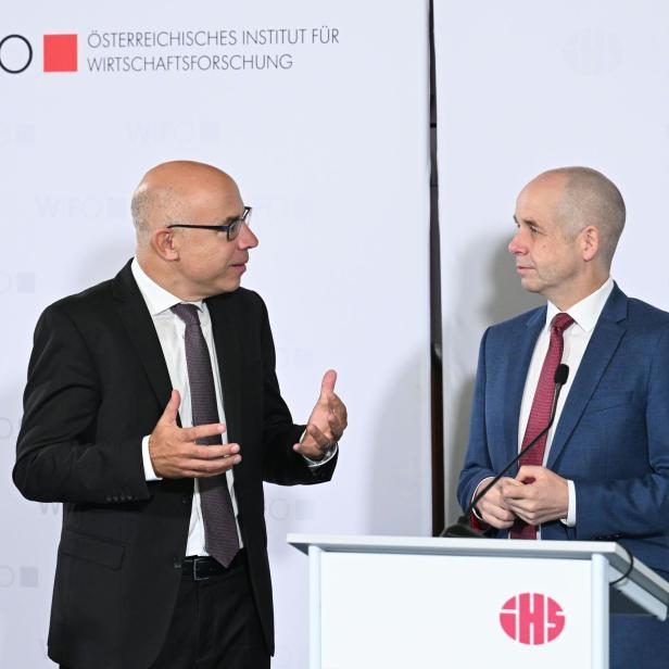 : Wifo-Chef Gabriel Felbermayr und IHS-Chef Holger Bonin stehen vor einer weißen Wand und unterhalten sich.