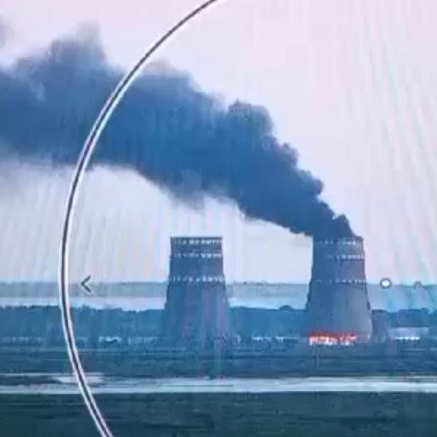 Zwei AKW-Türme: Aus einem steigt Rauch auf, man sieht Feuer davor.