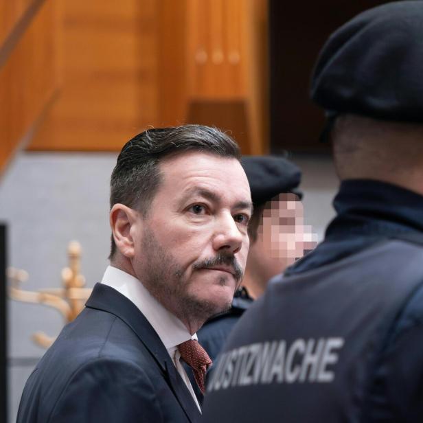 René Benko beim Prozess – flankiert von Justizwachebeamten