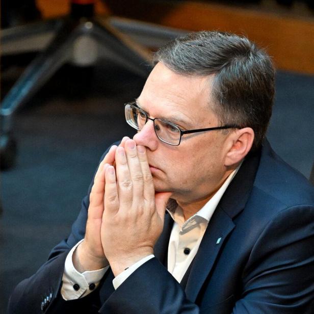 August Wöginger sitzt nachdenklich mit gefalteten Händen vor dem Gesicht im Nationalrat