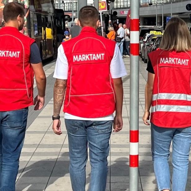 Drei Mitarbeitende des Marktamts der Stadt Wien von hinten